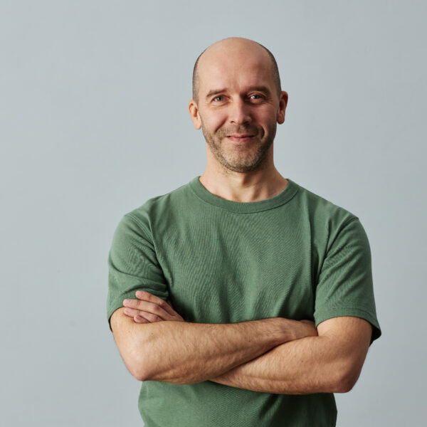 Man in green shirt smiling confidently